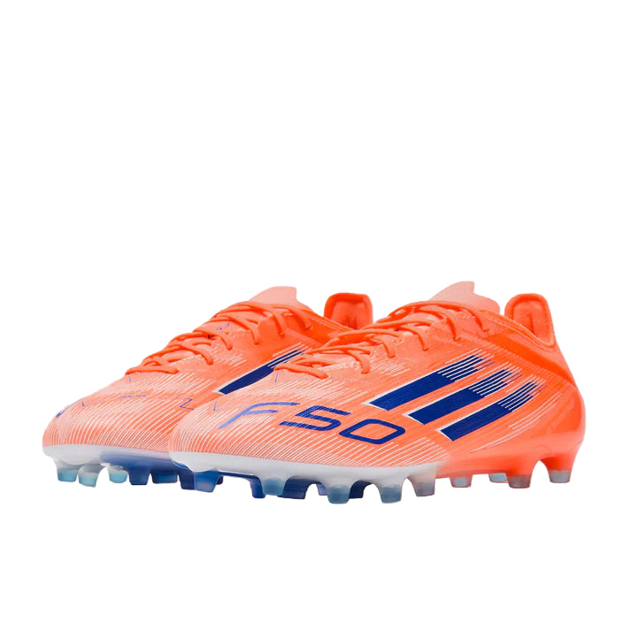 Orange soccer cleats with blue accents on a light gray background